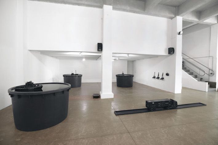 Emigration Made Pavilion 148 Installation View at Prometeo Gallery Ida Pisani, Milan, 2015 PVC water container, black pigment, water, wood structure, remote control boat and truck, variable dimensions © Giuseppe Stampone
